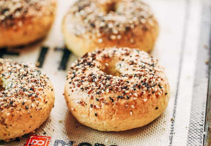 Close up of grain free seed topped bagels on a baking sheet