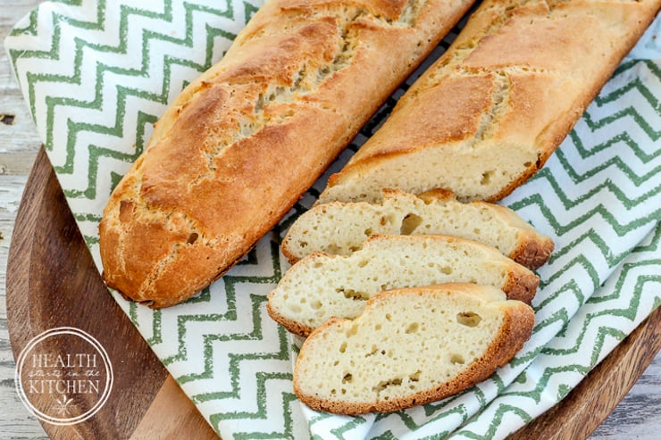 two grain free french bread rolls with three slices splayed out of one 