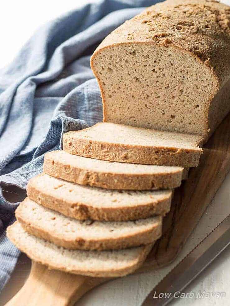 Pane keto con la metà tagliata su un tagliere di legno