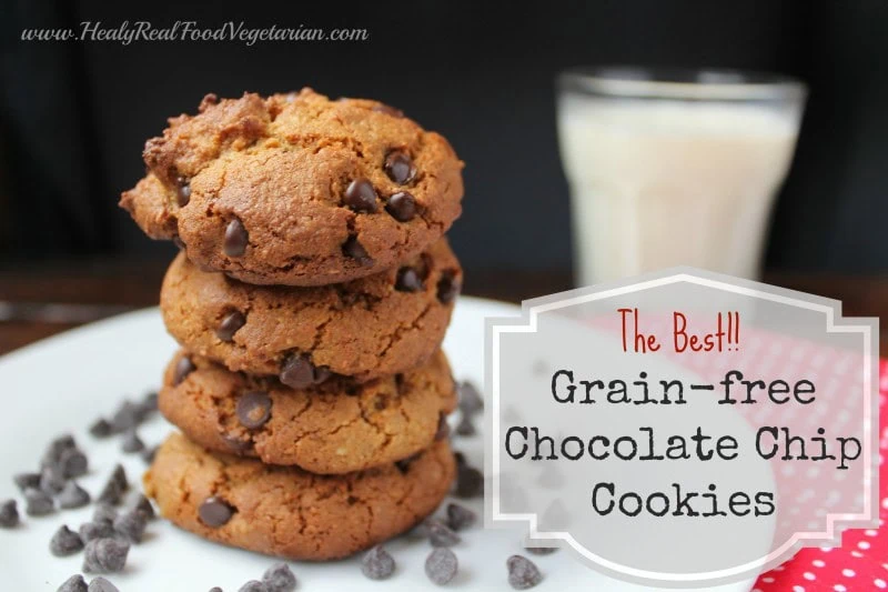 A pile of almond flour chocoalte chip cookies on a work surface with a glass of milk