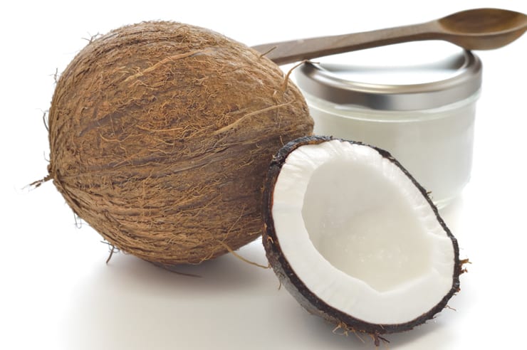 Coconut and organic coconut oil on a white surface