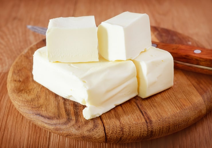 A photo of cubes of butter on a wooden chopping board