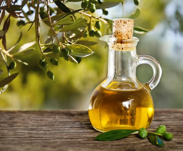 Olive oil and olive branch on the wooden table