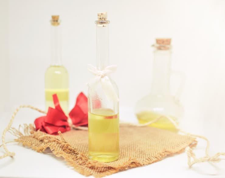 Tall glass bottles of oil on a burlap cloth