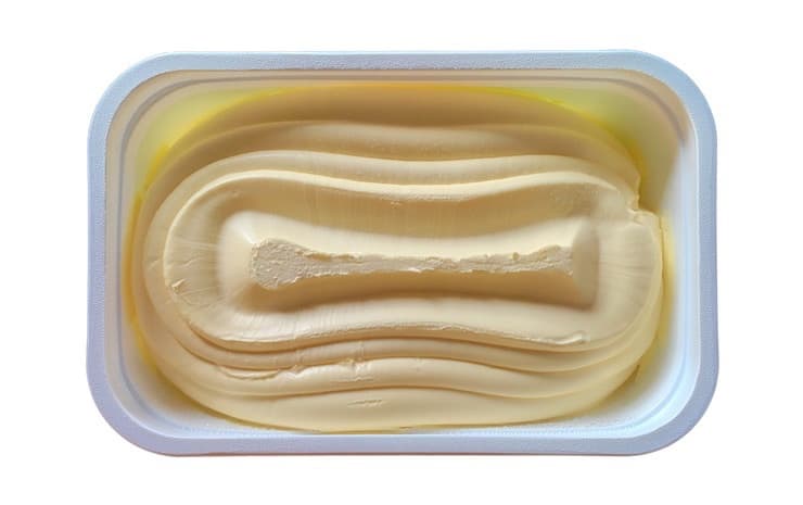 Open tub of margarine with white background