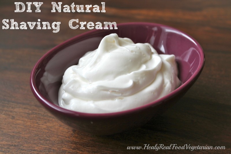 A photo of DIY shaving cream in a small purple bowl sitting on a wooden surface