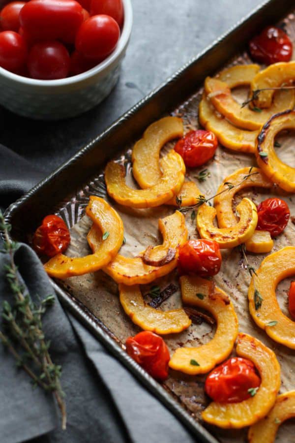 Roasted cut up squash and tomatoes on a tray
