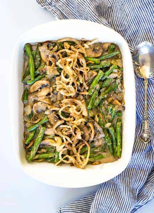 A green bean casserole in a white dish topped with crispy onions