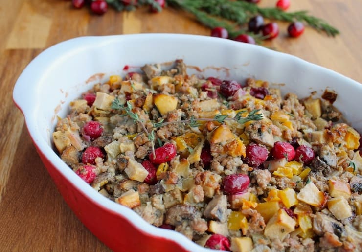 White and red dish filled with paleo stuffing with cranberries and herbs