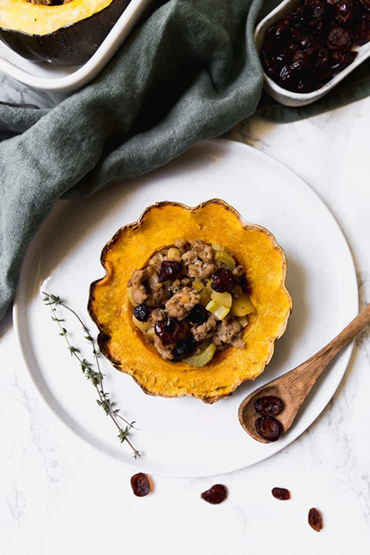 Half a stuffed acorn squash on a plate with a fork
