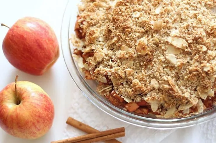 An overhead shot of a paleo apple crisp with apples at the side