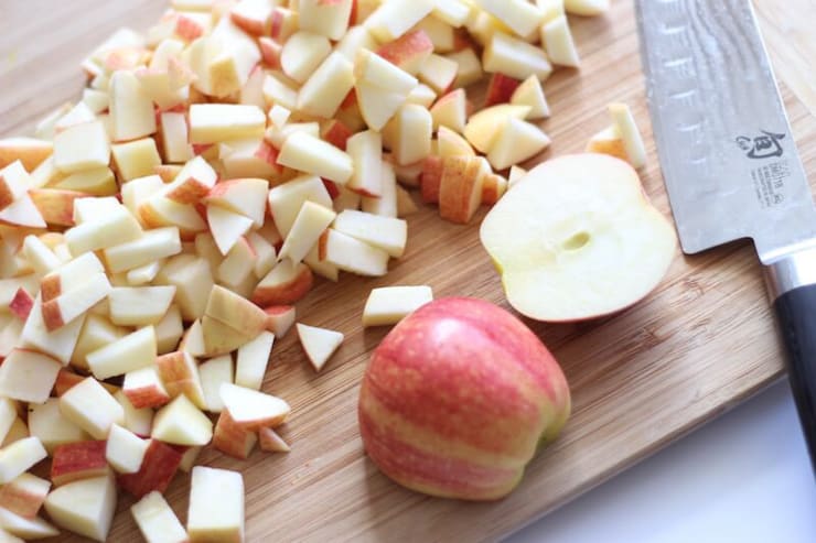 Chopped up apples on a wooden board for an apple pie filling