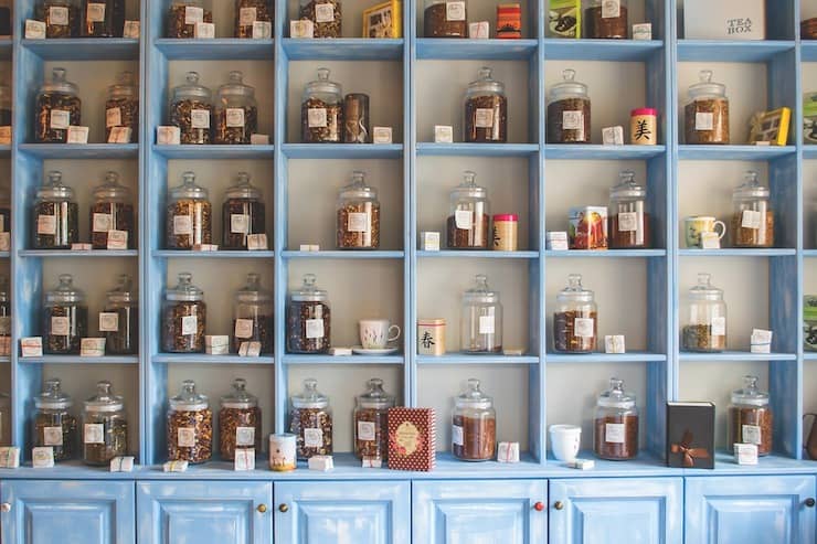 Wall shelf with various glass jars of herbs