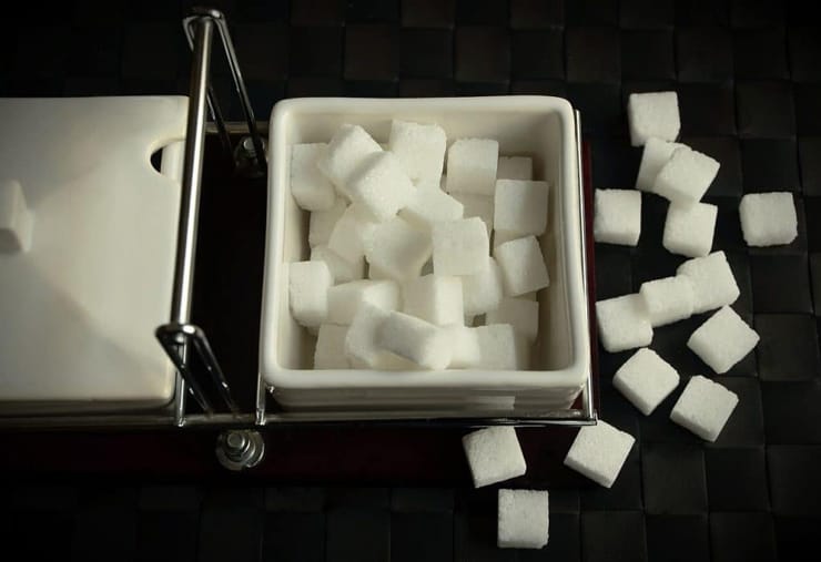 An overhead shot of sugar cubes in a white ramekin