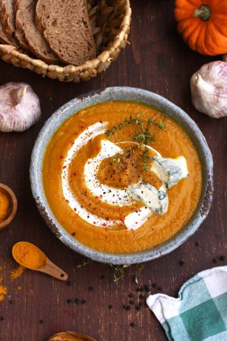 A bowl of butternut squash soup with a sour cream swirl on the top