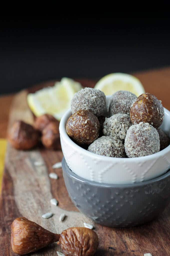 white bowl stacked on grey bowl filled with sunflower balls on wooden surface