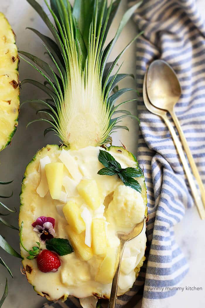 halved pineapple with scooped out flesh with pineapple ice cream inside