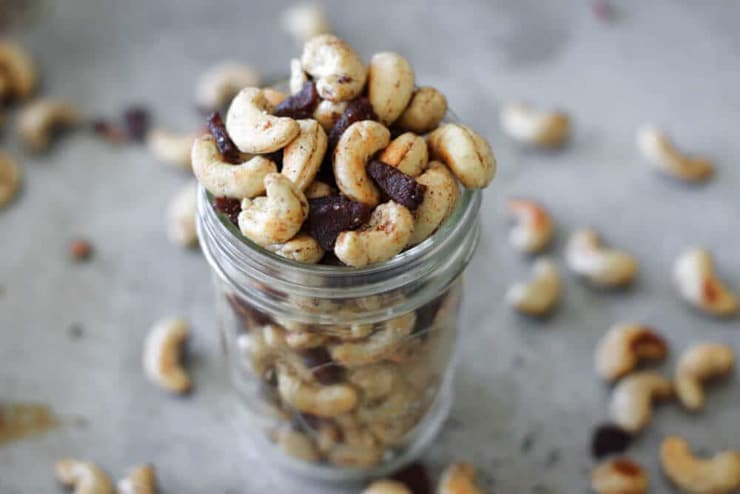 A glass jar filled with spiced bacon cashews and other nuts