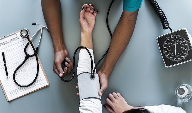 arms of a doctor taking blood pressure from patient