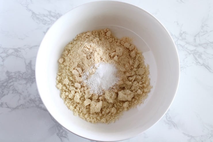 Dry paleo biscuit ingredients in a white bowl on a marble counter