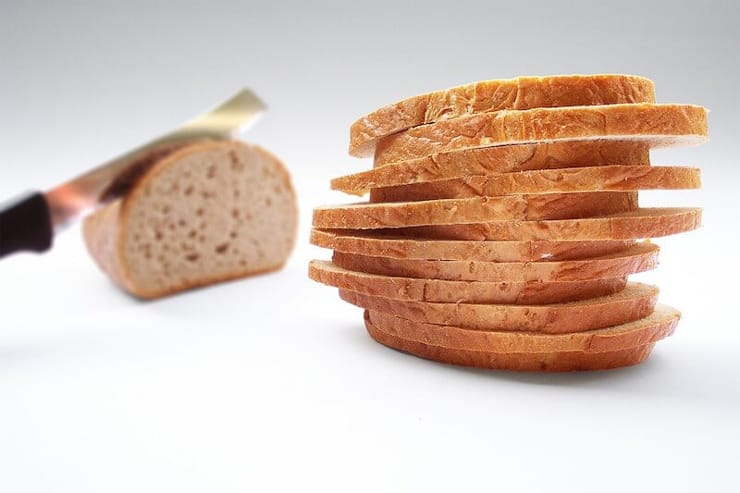 A pile of sliced bread sitting on a work surface