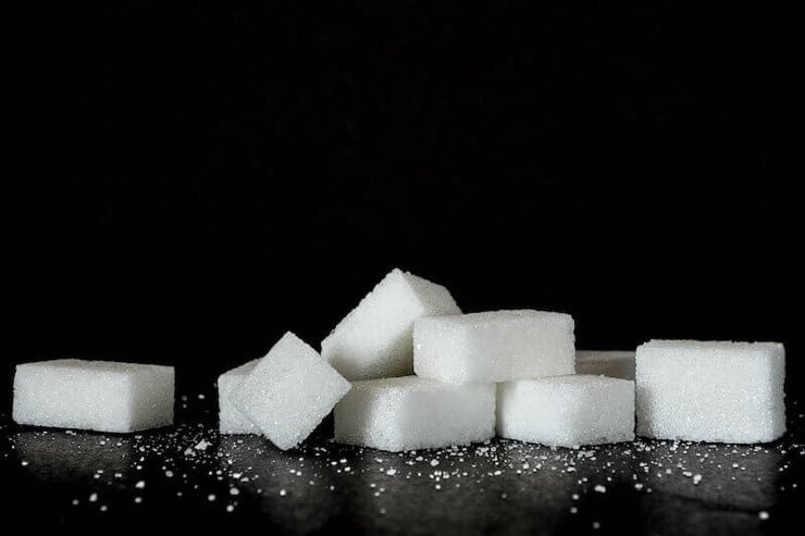 sugar cubes in a small pile on a black surface