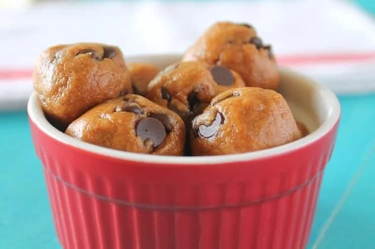 A red ramekin filled with chocolate chip energy balls