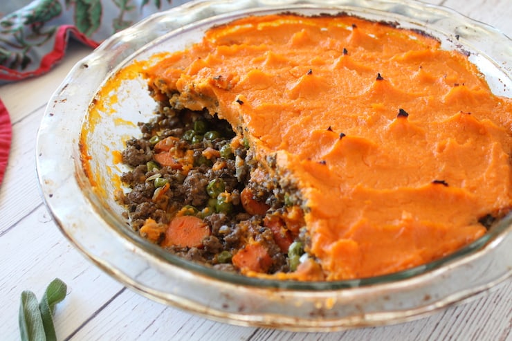 Close up of shepherd's pie in a clear pie dish with pieces taken out of it