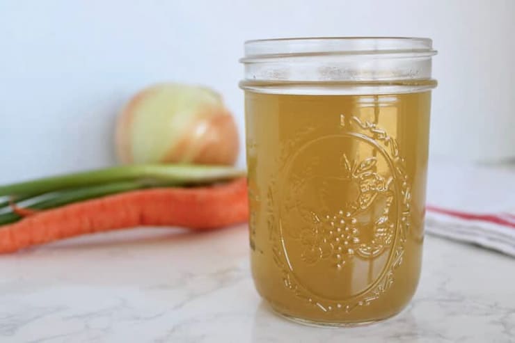 A jar of bone broth on a white surface