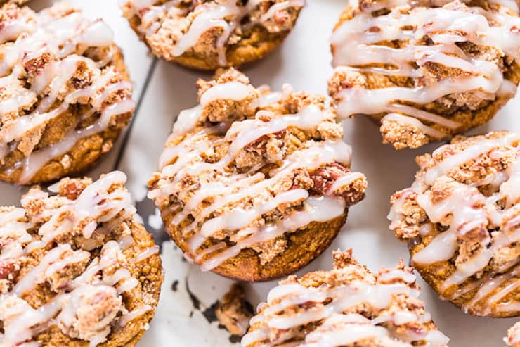 CLose up of several pumpkin spice muffins drizzled with white frosting