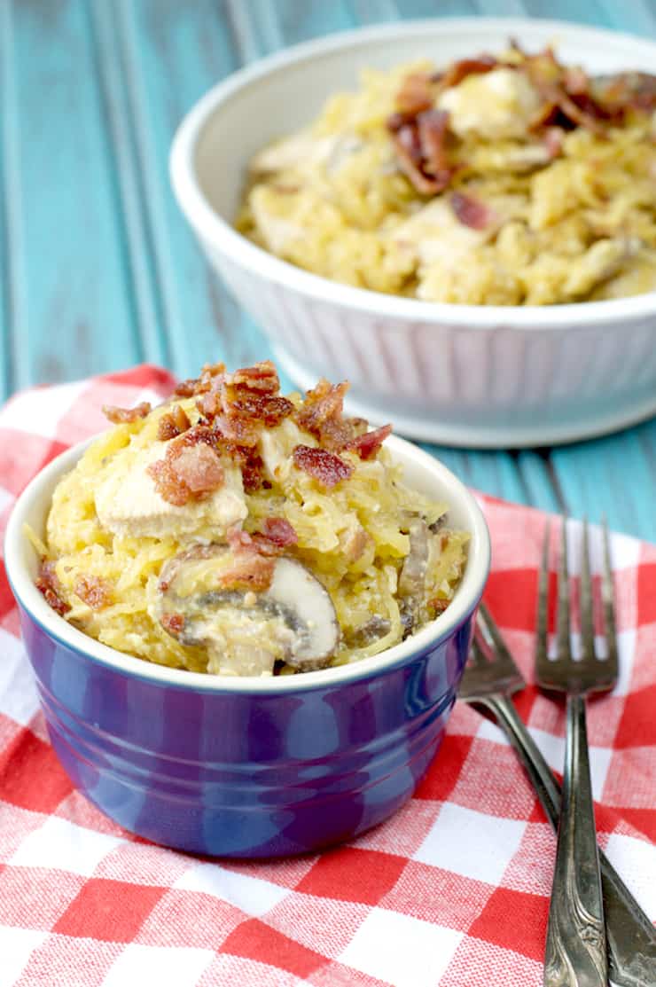 Small blue ramekin filled with spaghetti squash pasta topped with bacon crumbles