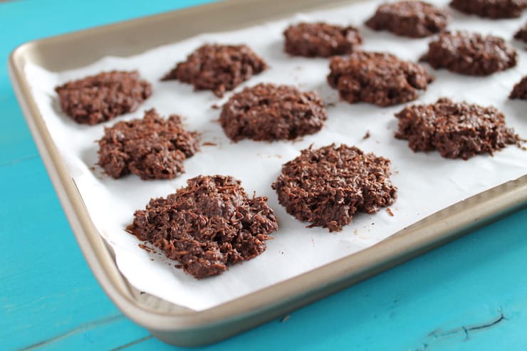 chocolate coconut haystack cookies on white parchment paper on a baking sheet