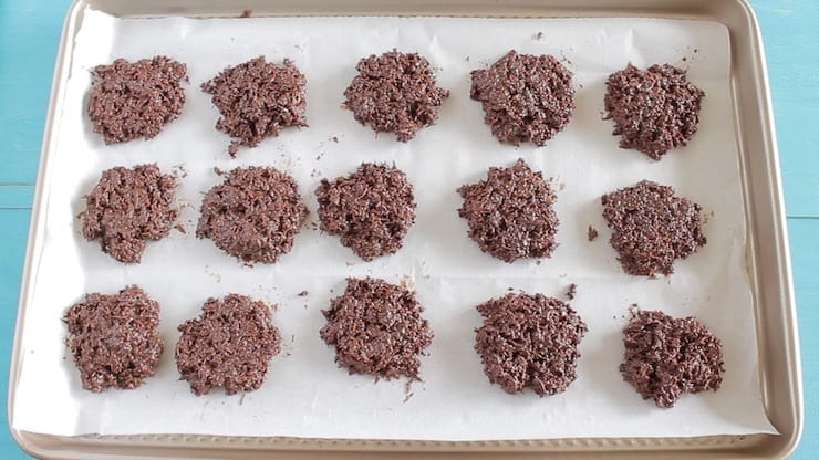 Heaps of chocolate coconut mixture on white parchment paper on a baking sheet
