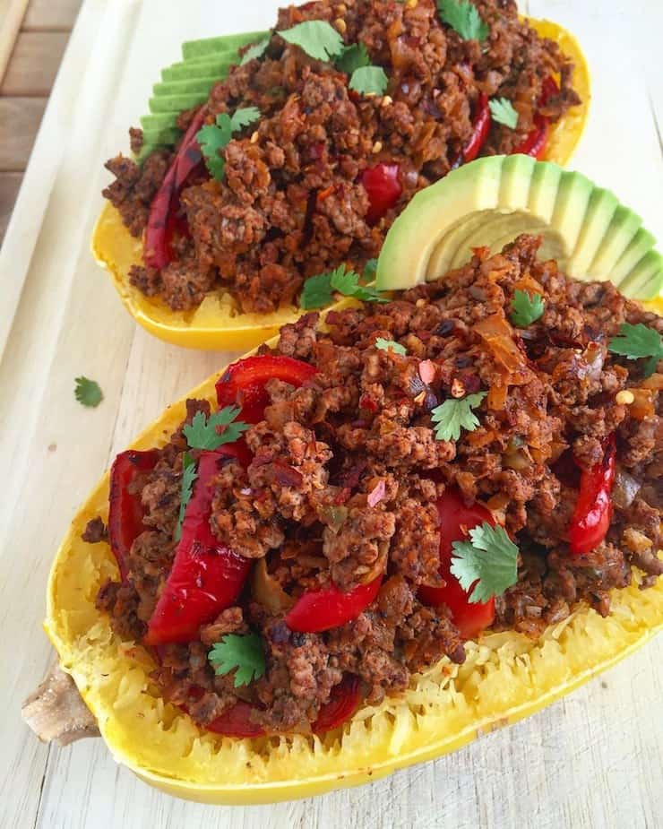 Halved cooked spaghetti squash filled with heaping beef and pepper and avocado