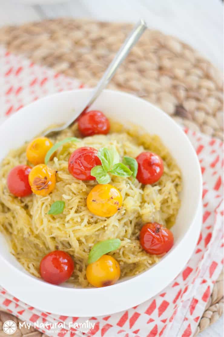 White bowl filled with yellow spaghetti squash and grape tomatoes
