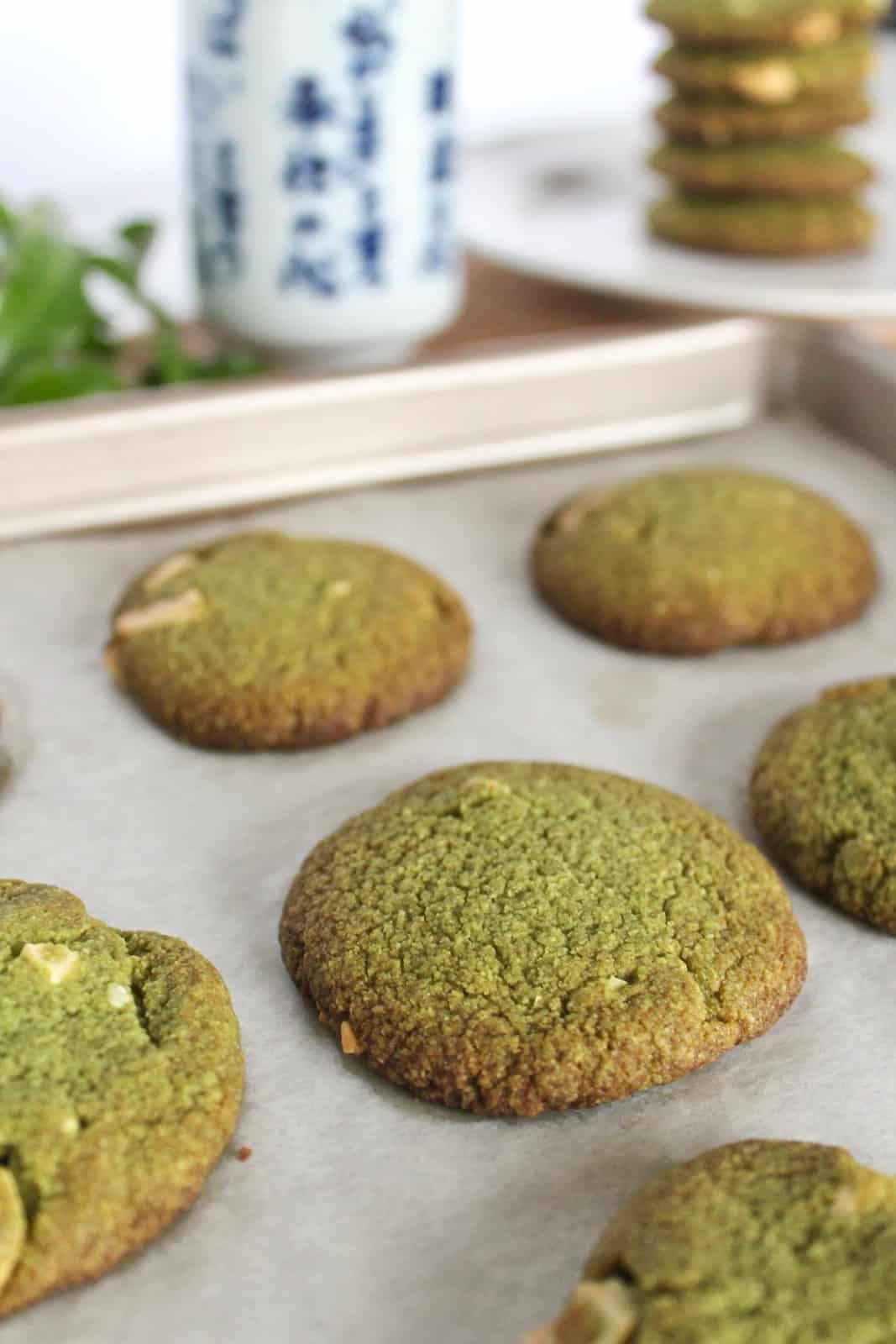 Close up of finished green cookies on a baking sheet lined with parchment paper
