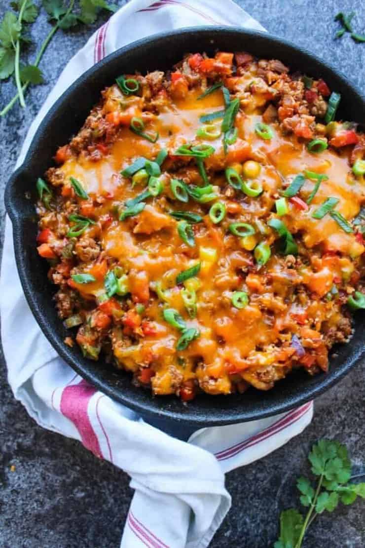 AN overhead shot of a taco skillet with a tea towel around the handle