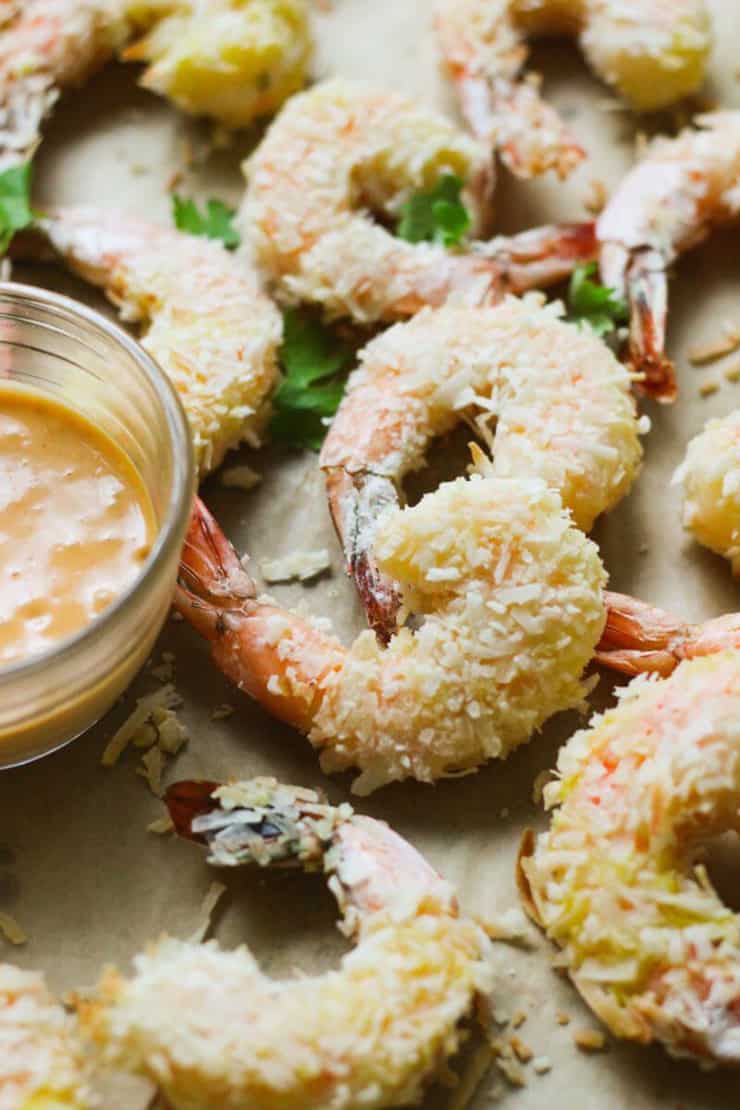 A closse up of pealo coconut lime shrimp with a dipping sauce