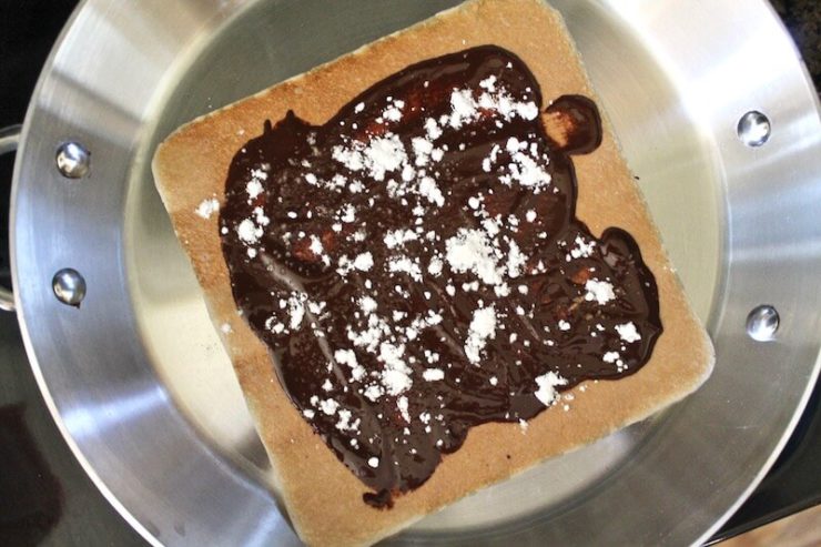 pan with open coconut wrap with melted chocolate and powdered sugar on top