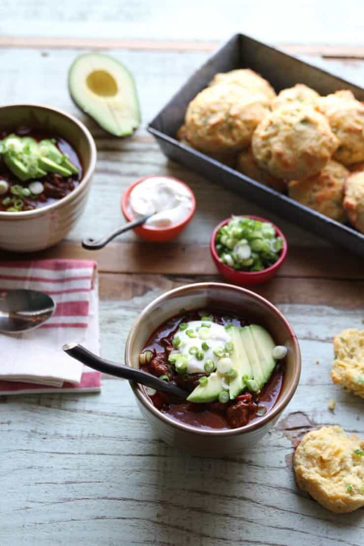 A small bowl filled with healthy chili and topped with avocado