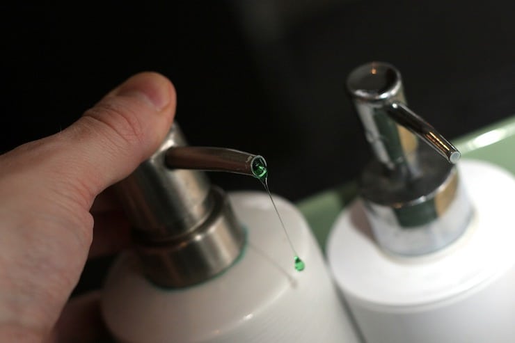 white liquid soap dispenser with green soap coming out