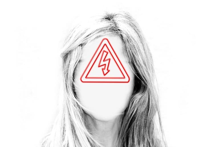 Woman with white out face and red warning sign triangle over face