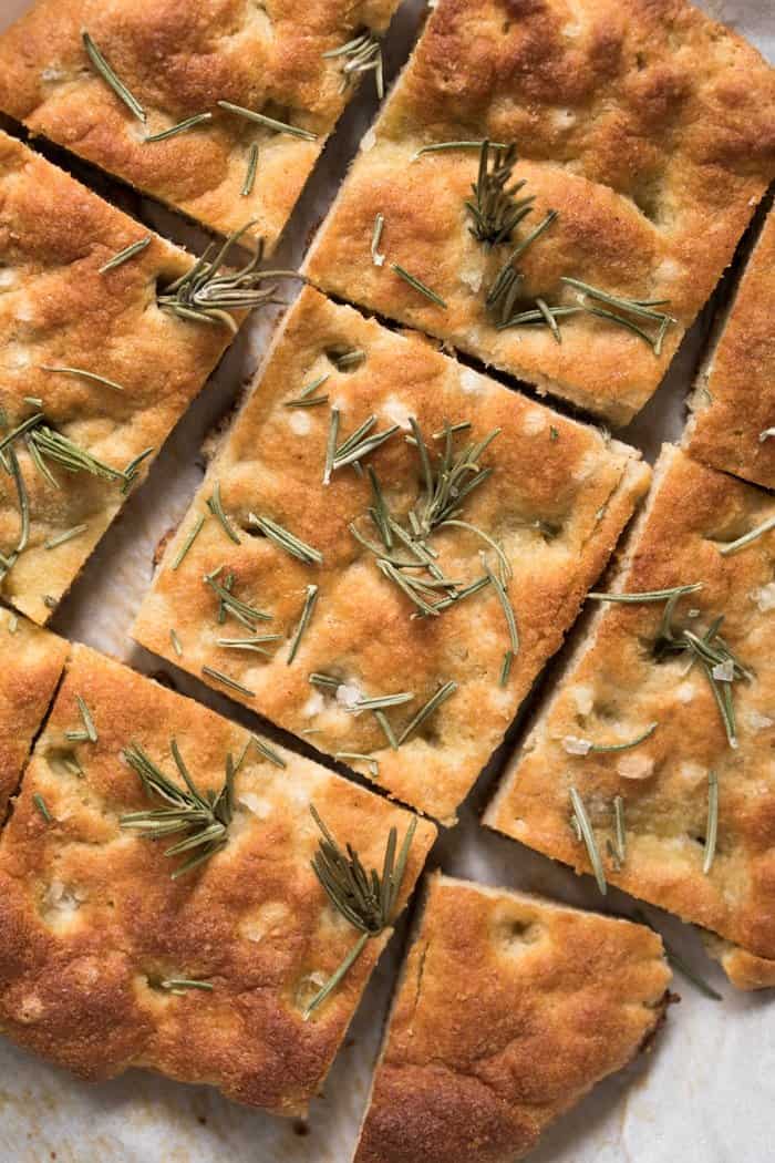 Close up van graanvrij focaccia brood belegd met rozemarijn en zeezout in vierkantjes gesneden