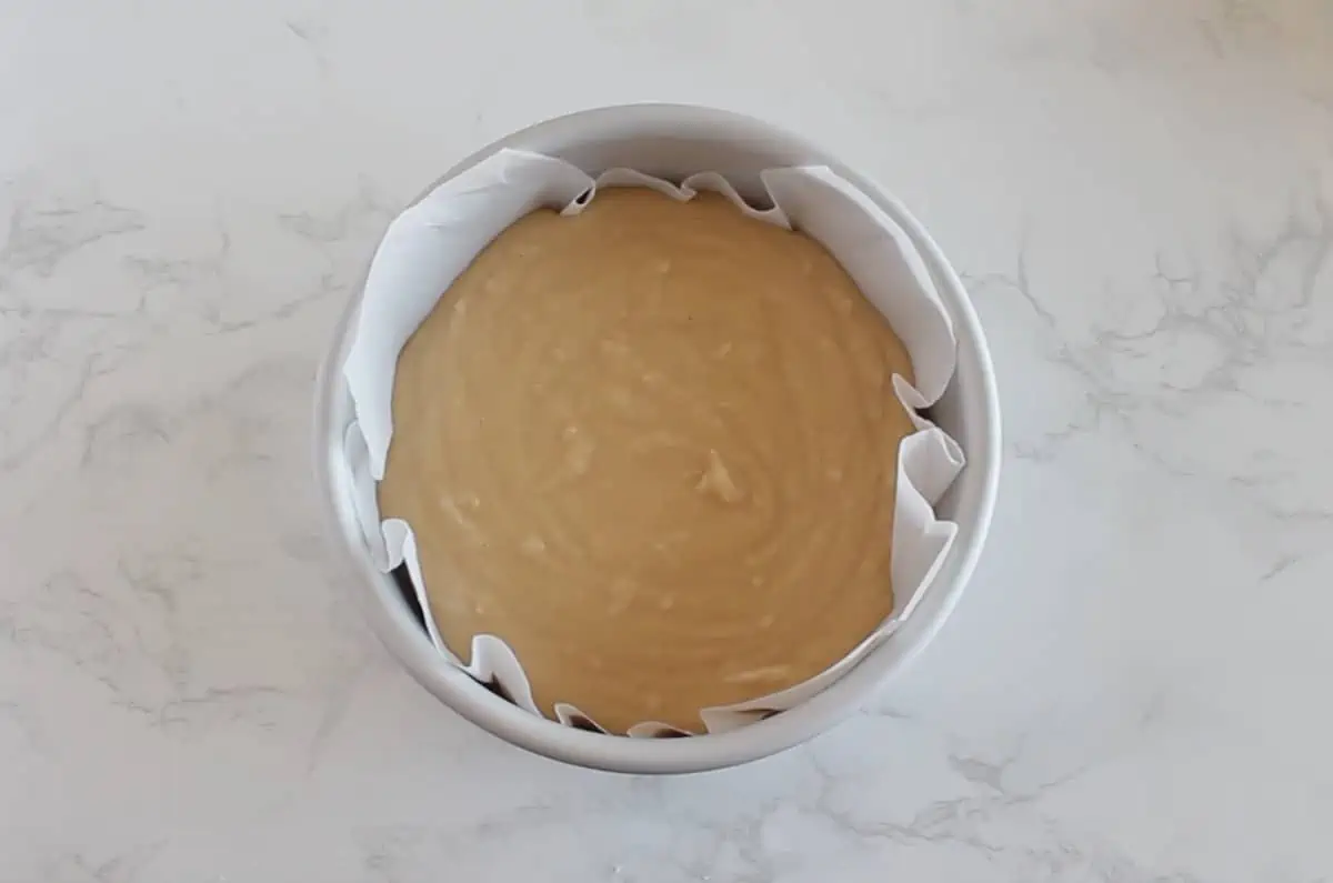 Coconut flour cake batter in metal cake pan lined with white parchment