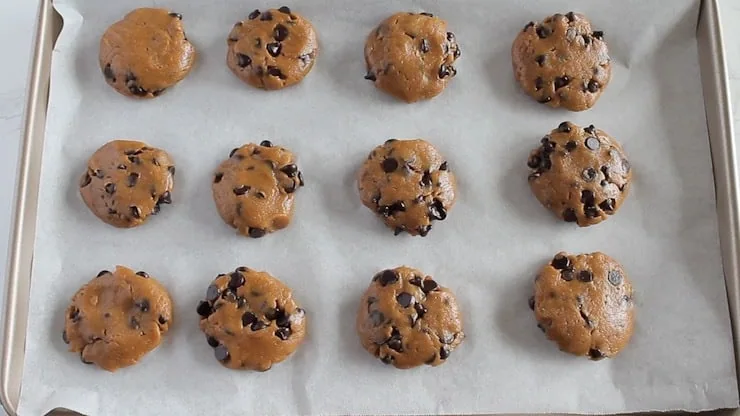 Overhead view of uncooked keto chocolate chip cookies on baking sheet