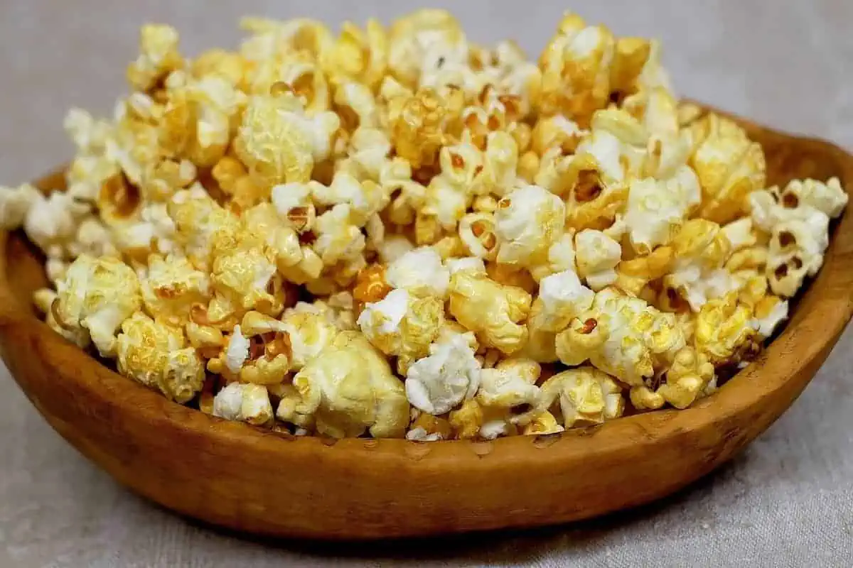 Popcorn in a wooden bowl on a grey surface