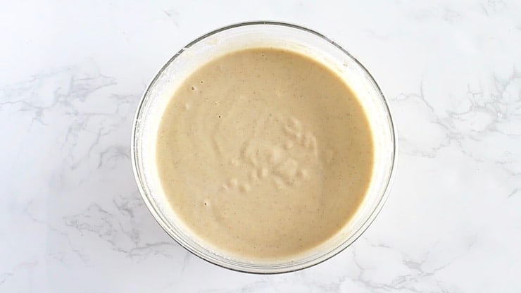 Overhead view of blended applesauce muffin batter in a clear bowl