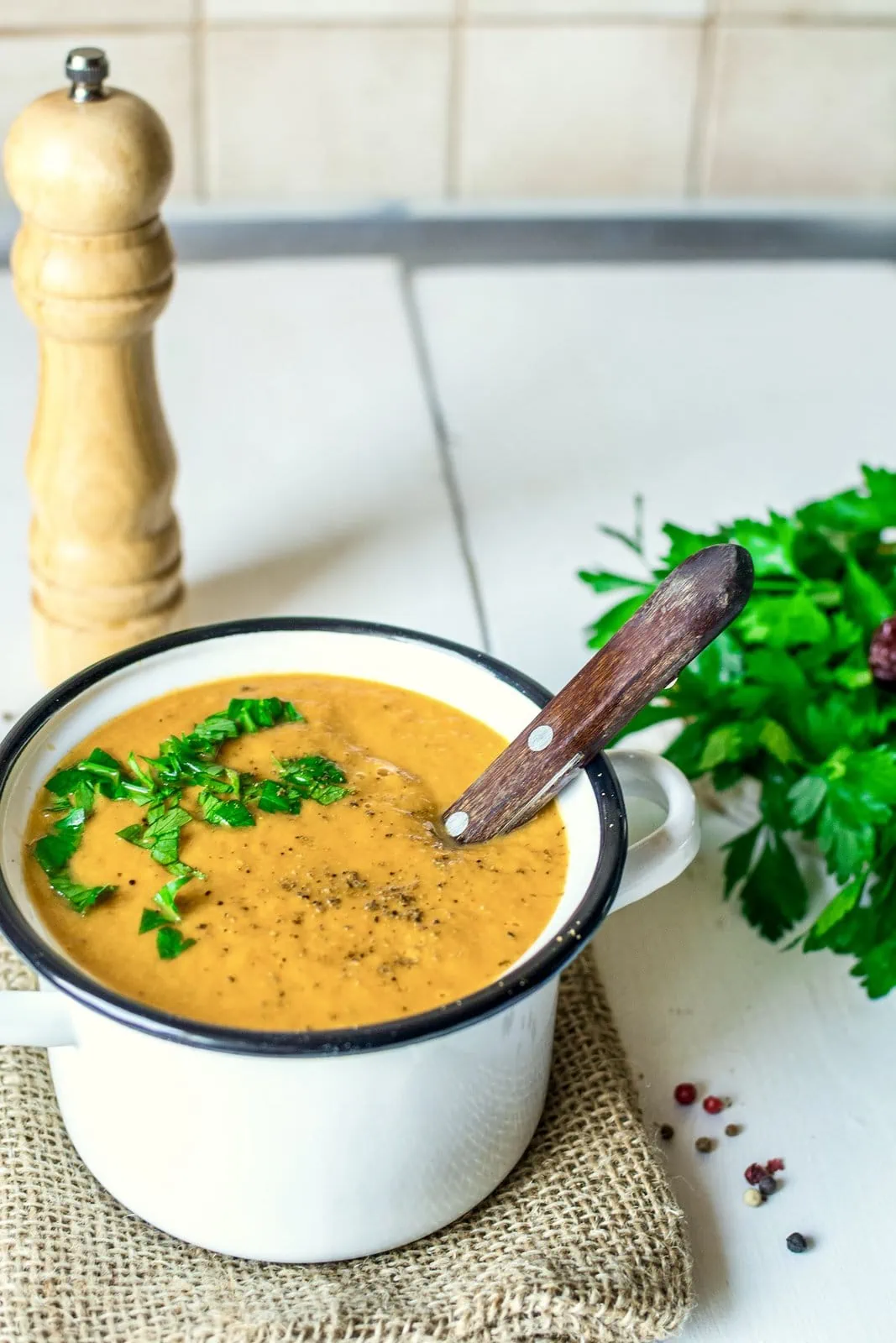 A bowl of creamy roasted vegetable soup with parsley.