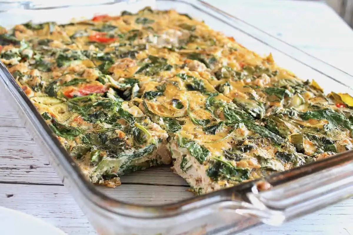 turkey and veggie baked frittata in a clear rectangular baking dish on white wooden surface