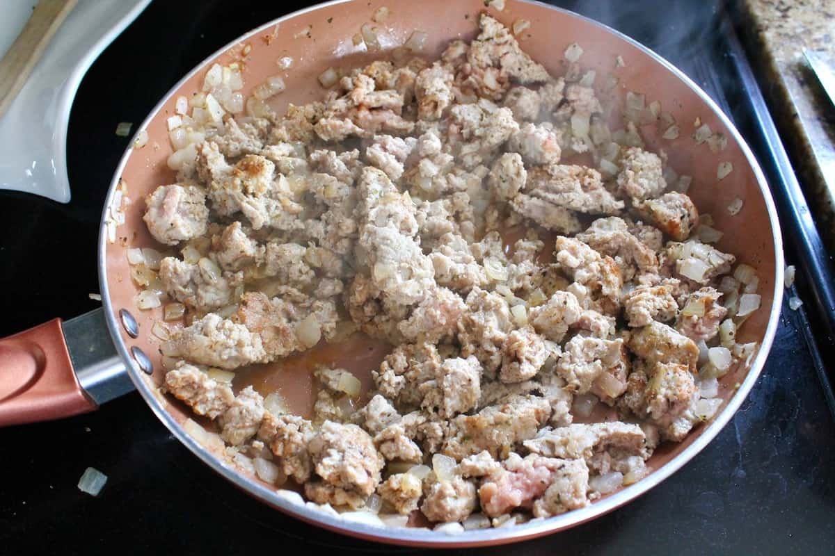Seasoned ground turkey cooking in a pan on the stove